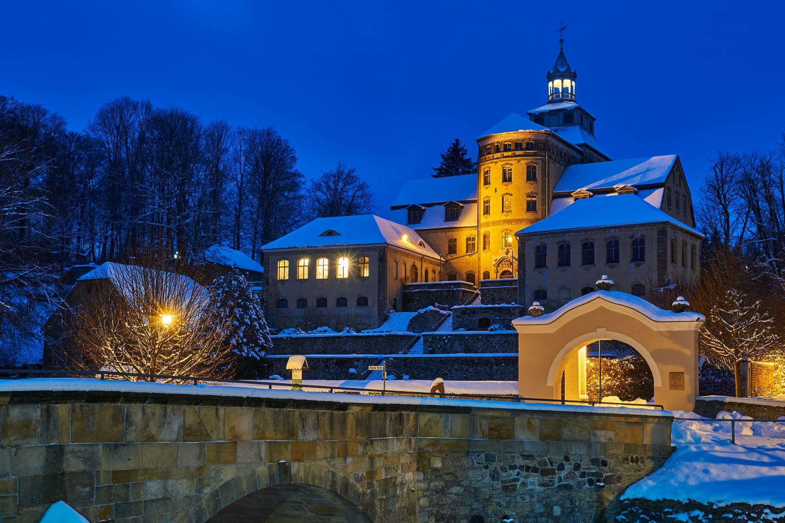 Beleuchtetes Schloss Hainewalde bei Dunkelheit im Winter
